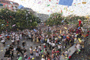 plaça plena de gent amb molt de confeti a l'aire