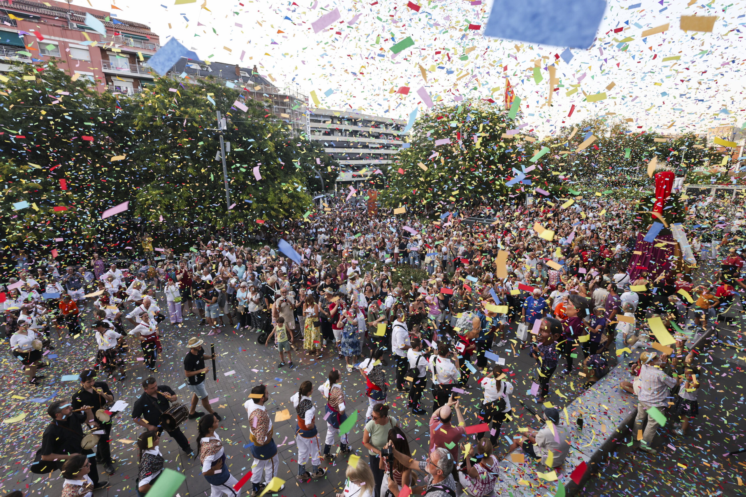 plaça plena de gent amb molt de confeti a l'aire