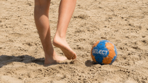 platja amb uns peus i una pilota d'handbol